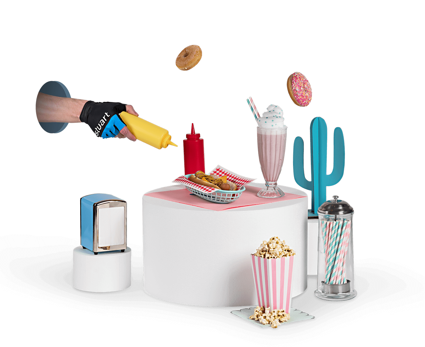 Hand wearing a Stuart glove pouring mustard over fast food on a white podium with popcorn, a milkshake and doughnuts